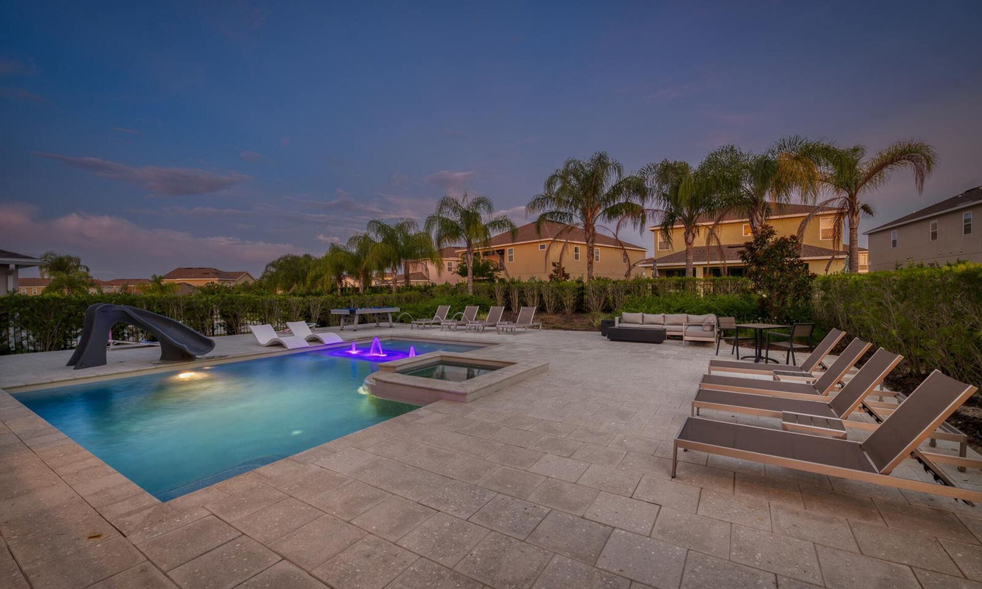 Exterior of a luxury vacation villa at Encore Resort at Reunion featuring unique stone turrets, blue tiled roofing, and arched windows under a blue sky.