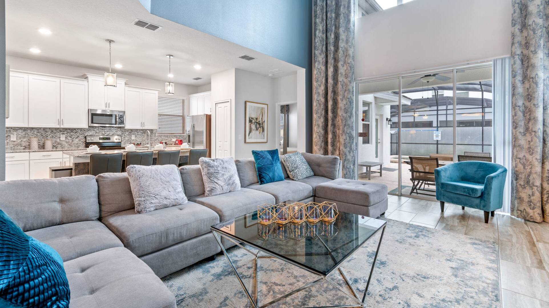 Open plan living room, full kitchen and screened pool lanai inside a Storey Lake Resort villa Orlando