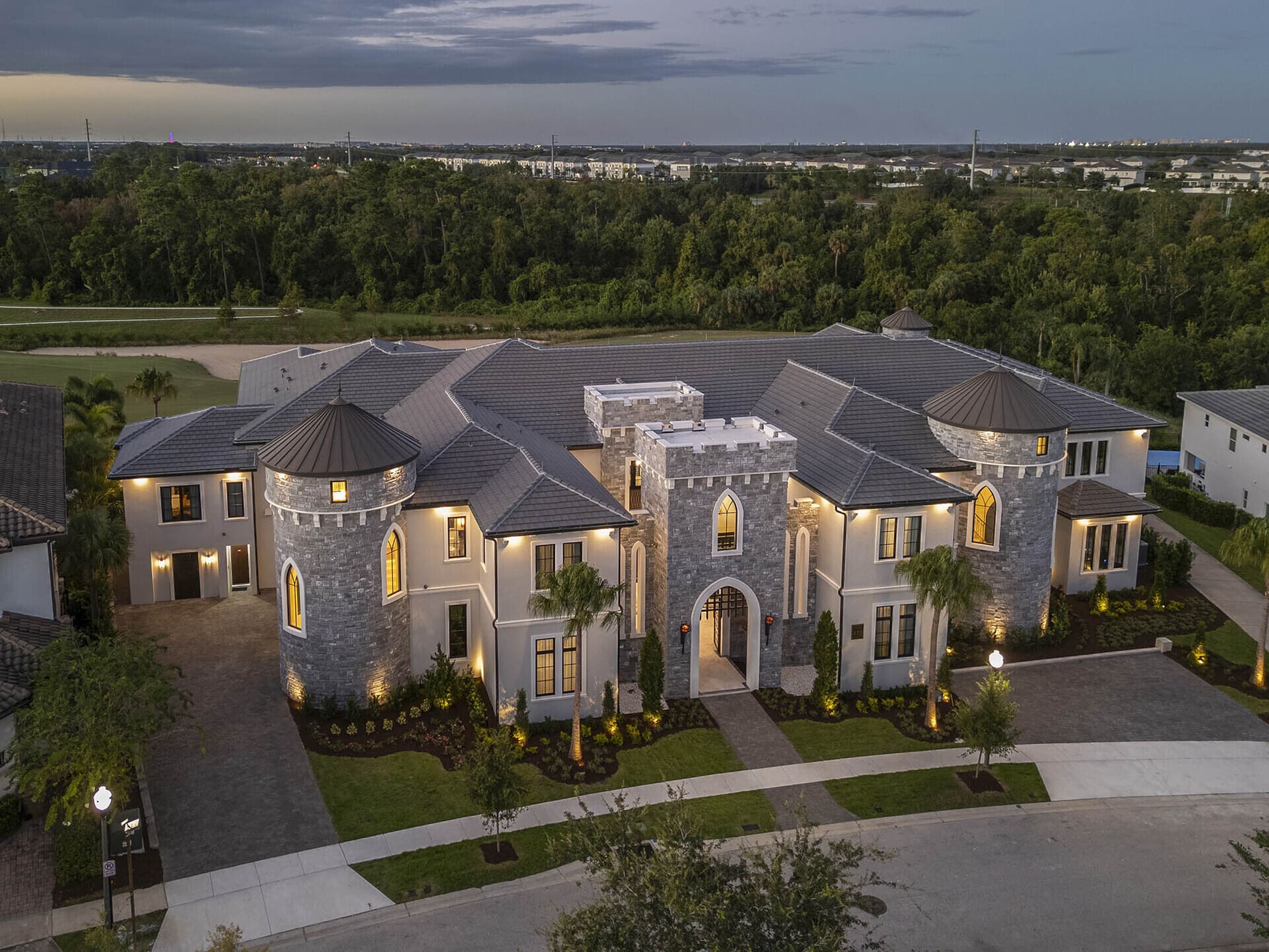 Aerial dusk view of a Kissimmee villa rental with turret architecture, near Orlando theme parks